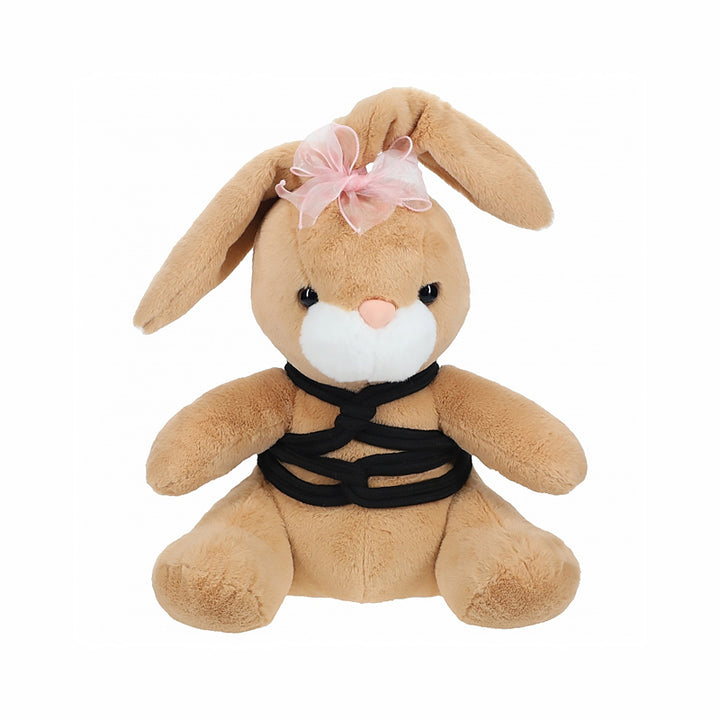 Brown plush bunny with pink bow and black decorative rope harness sitting against white background