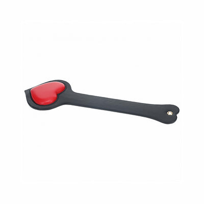 Black leather paddle with a red heart-shaped padded tip and iridescent hardware detail on the handle.