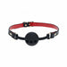 Black silicone ball gag with ventilation holes and adjustable black and red bonded leather straps with gold hardware.