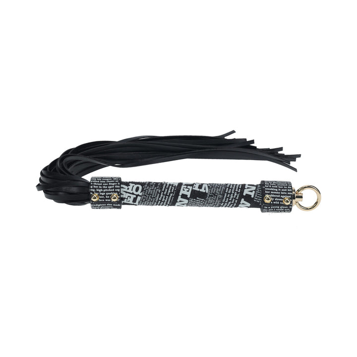 Black leather flogger with printed text handle and iridescent metal ring detail on a white background
