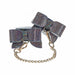 Iridescent bonded leather leg cuffs with bow design and gold chain connectors, adorned with sparkling rhinestones.