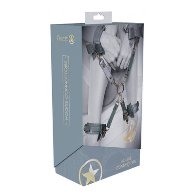 Packaging of Ouch! Paris Collection Hogtie Connectors showing iridescent bonded leather straps and metal hardware on restrained wrists and ankles.