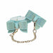 Light blue iridescent leg cuffs with rhinestone-studded bows and gold chain connectors.