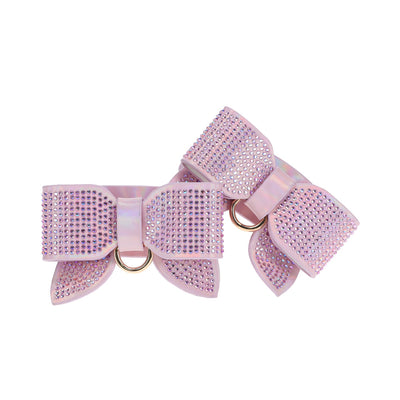 Pair of iridescent pink leg cuffs adorned with sparkling rhinestones and gold-tone rings, shaped like bows.