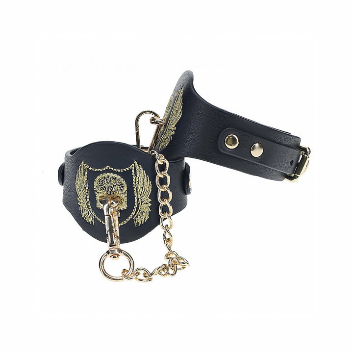 Black bonded leather handcuffs with gold embroidered crest and gold chain from the Ouch! London Collection.