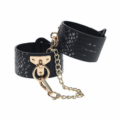 Black faux leather handcuffs with textured snake pattern and gold-tone chain and hardware.