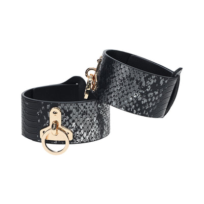 Black faux snakeskin leg cuffs with gold-tone hardware and adjustable straps from the Ouch! Florence Collection.