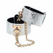 White faux snakeskin leg cuffs with gold-tone chain and hardware, adjustable and stylish restraint accessory.