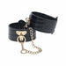 Black crocodile-texture leg cuffs with gold-tone chain and hardware detail on a white background.