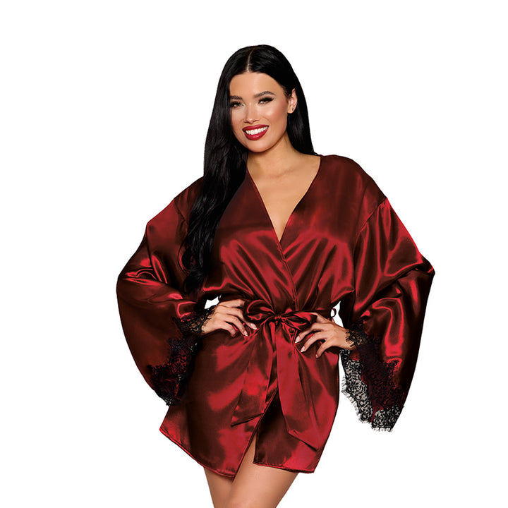 Woman wearing an oxblood satin robe with black lace trim and a tied waist, smiling with long dark hair.
