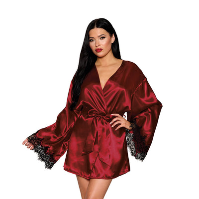 Woman wearing oxblood satin robe with black lace trim and wide sleeves, tied at the waist with a matching sash.