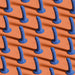 Pattern of multiple blue speckled silicone dildos with suction cup bases on an orange background.