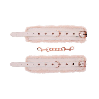 Peach-colored faux fur handcuffs with rose gold hardware and detachable chain, adjustable buckle straps.