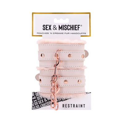 Peach-colored faux fur handcuffs with rose gold chain and hardware on branded Sex & Mischief packaging.
