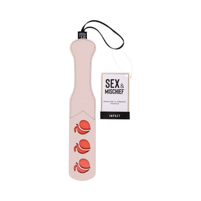 Light pink faux leather paddle with three peach cutouts and attached wrist strap, labeled Sex & Mischief Peaches n Creame Paddle.