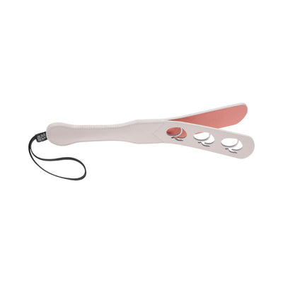 Light pink faux leather paddle with peach-shaped cutouts and a black wrist strap, split tip design.
