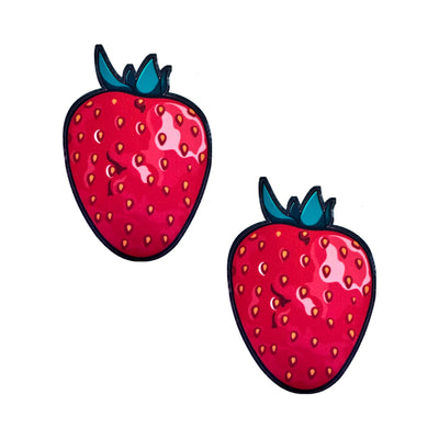 Pair of red strawberry-shaped edible nipple pasties with green leaves and glossy finish on white background.