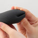 Close-up of hands holding the sleek black iroha+ YORU Renewal vibrator with soft, curved silicone design.