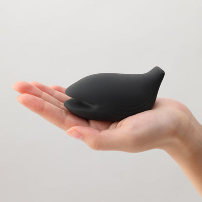 Compact black silicone iroha+ YORU Renewal vibrator shaped like a smooth bird held in an open hand.
