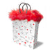 White gift bag with playful stick figure illustrations and red hearts, topped with bright red marabou fringe and gray handles.
