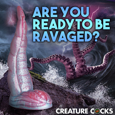 Iridescent red and blue silicone tentacle dildo with textured suckers and wide suction base against a stormy ocean background.