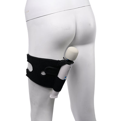 Black adjustable thigh strap worn on a mannequin leg, holding a white wand vibrator securely in place.