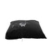 Black waterproof pillow protector with water splashing on top, demonstrating liquid resistance.