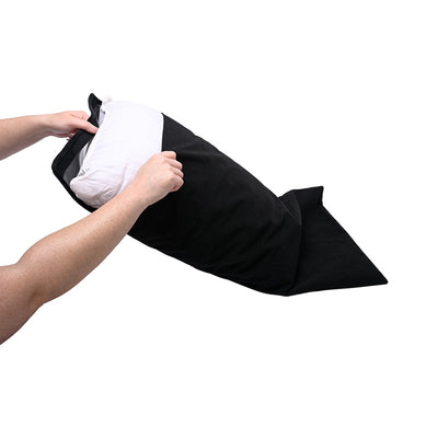 Hands inserting a white pillow into a black Sportsheets Pivot Pillow Protector with hook and loop closure.