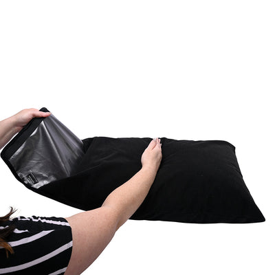 Hands holding open a black Sportsheets Pivot Pillow Protector showing its waterproof inner lining and hook-and-loop closure.