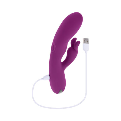 Purple silicone rechargeable dual stimulator vibrator with USB charging cable on white background