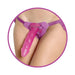 Close-up of a person wearing a purple adjustable strap-on harness with a pink dildo attached.