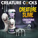 Bottle of Creature Slime unscented lubricant with animated white slime creatures and dripping slime graphics on dark background.