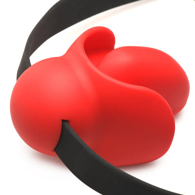 Close-up of a red silicone extreme gag with a black adjustable locking strap on a white background.