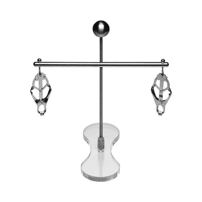 Adjustable stainless steel nipple clamps with rubber tips on a clear acrylic stand for customizable pressure play.