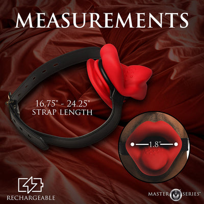 Red lips-shaped vibrating mouth gag with adjustable black strap on red fabric background, showing strap length and width measurements.