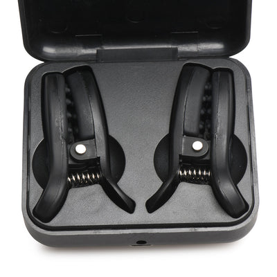 Black vibrating nipple clamps with textured silicone grips inside a compact rechargeable storage case.