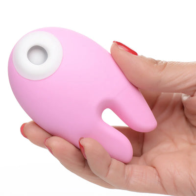 Hand holding a pink silicone clitoral stimulator with dual bunny ear design and a white suction opening.