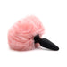 Soft pink fluffy bunny tail attached to a black silicone plug with SnapOn base on white background