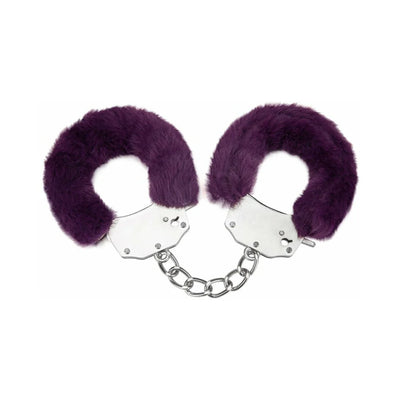 Pair of metal handcuffs wrapped in soft purple furry covers connected by a short chain on white background.