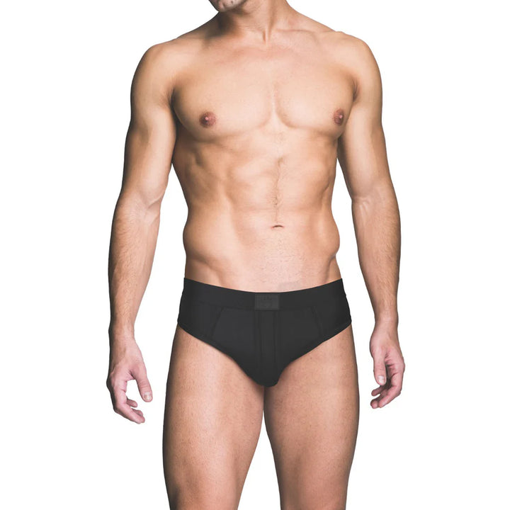 Male model wearing black Prowler ass-less brief underwear, front view on white background.