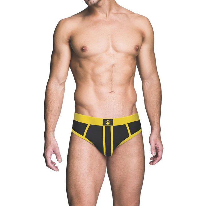 Male model wearing black and yellow brief with a paw print logo on the waistband, front view on white background.