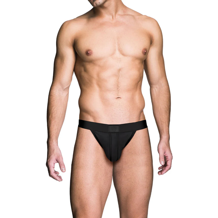 Male model wearing a black Prowler Red Ass-Less Jock with an open-back design on a white background.