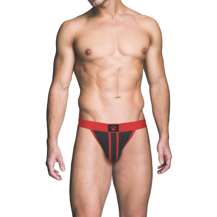 Male model wearing a red and black Prowler ass-less jockstrap with a paw print logo on the waistband.