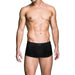 Male model wearing black Prowler Red Ass-Less Trunk underwear, front view on white background.