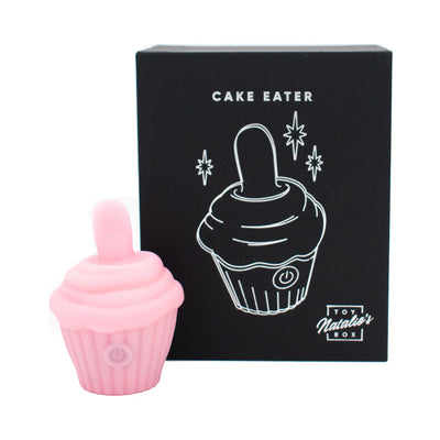 Pink silicone cupcake-shaped flicker stimulator with a soft tongue, displayed next to its black packaging box.