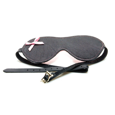 Black leather blindfold with pink stitching, soft pink bow detail, and adjustable buckle strap.