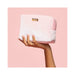 Hand holding a soft pink velvet VUSH storage case with gold logo plaque against a matching pink background.