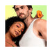 Couple posing with the orange VUSH Sol Vibrating Stroker held near the man's shoulder against a gradient background.