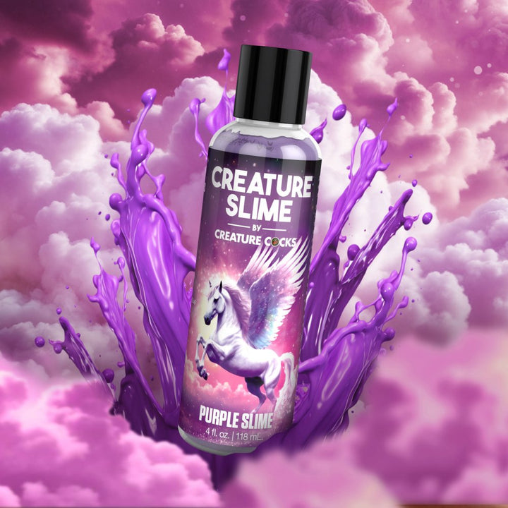 Bottle of Creature Slime purple water-based lubricant with a winged unicorn on the label surrounded by purple slime splash and pink clouds.