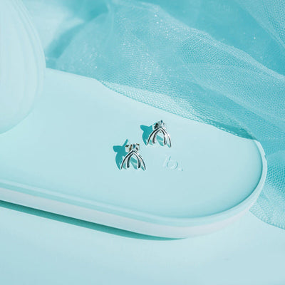 Sterling silver Biird Clit Earrings displayed on a light blue tray with sheer fabric background.